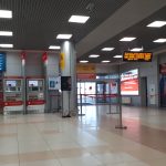 Светлая крытая платформа Аэроэкспресса в аэропорту Шереметьево с красными поездами и указателями