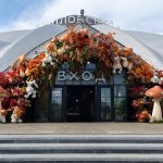 Вход в Даниловский рынок с белым шатровым куполом, арка украшена осенними листьями, большими грибами и белыми зайцами