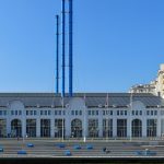 Белое здание ГЭС-2 с арочными окнами, синими трубами и башенкой со шпилем на Болотной набережной
