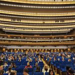 Большой зал Государственного Кремлёвского дворца: синие кресла партера, балконы и золотистые ряды светильников под потолком