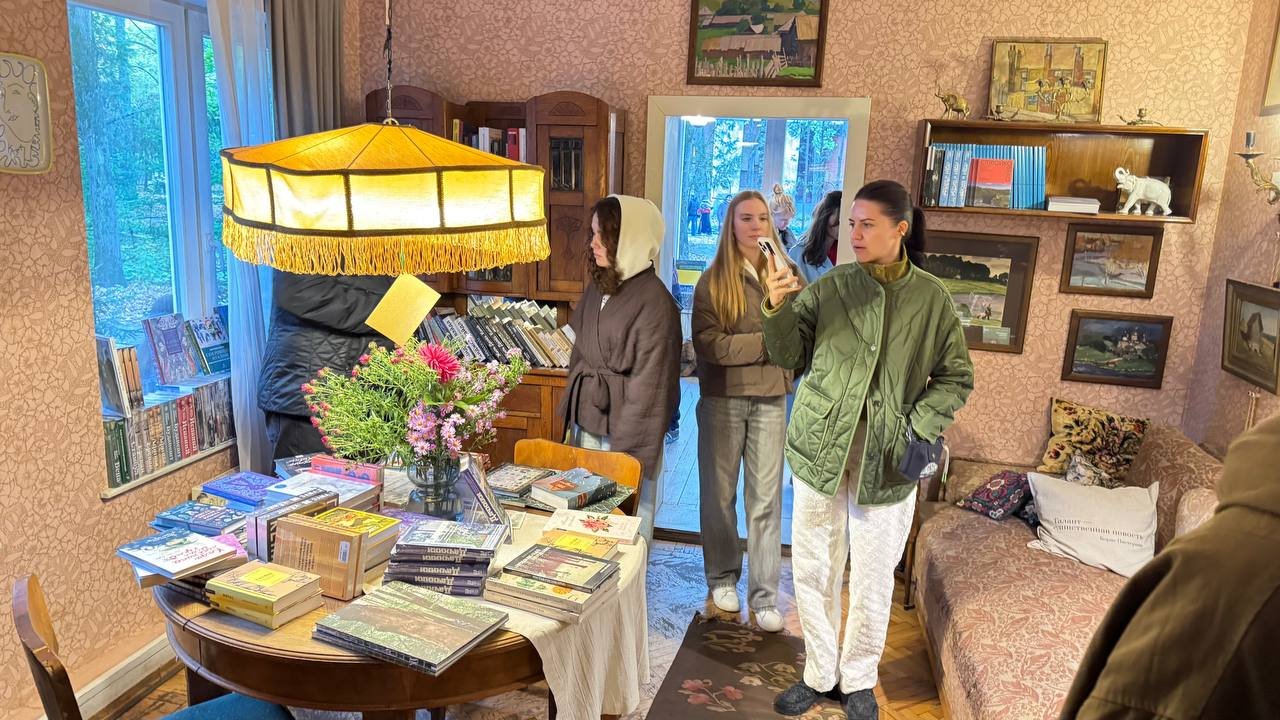 Комната дома-музея Пастернака: стол с книгами, цветами и жёлтым абажуром с бахромой