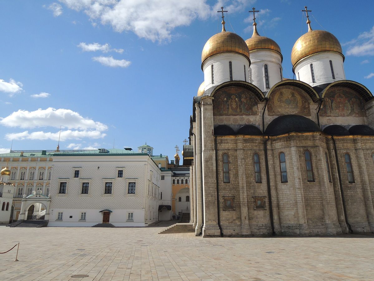 Белокаменный Успенский собор с пятью золотыми главами на фоне голубого неба